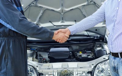 Car mechanic and customer shaking hands.